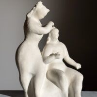 Alt text: Stylized, white sculpture of two women, one standing and one seated