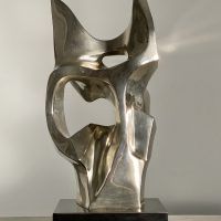 Alt text: Polished bronze sculpture of an abstract cat head, rear view