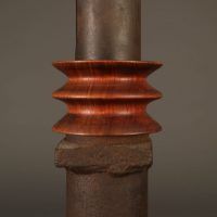 Alt text: Detail of abstract steel column with wood