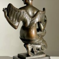 Alt text: Bronze sculpture of Philomela from Greek mythology, kneeling with wings growing from her back