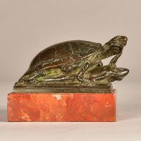 Alt text: Small bronze sculpture of a turtle eating a frog