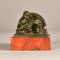 Alt text: Small bronze sculpture of a turtle eating a frog