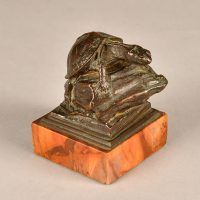 Alt text: Small bronze sculpture of a turtle atop a rock