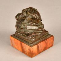 Alt text: Small bronze sculpture of a turtle atop a rock