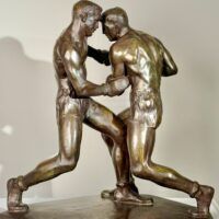 Alt text: Bronze sculpture of two boxers engaged in a fight