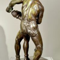 Alt text: Bronze sculpture of two boxers engaged in a fight