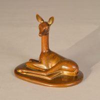 Alt text: Bronze sculpture of a doe lying down with her head and ears up, angled view