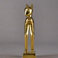 Alt text: Polished bronze sculpture of a long-legged fawn