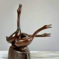 Alt text: Bronze sculpture of a group of three hissing geese