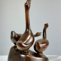 Alt text: Bronze sculpture of a group of three hissing geese