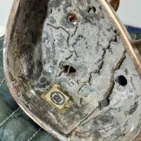 Alt text: Bronze sculpture, underside detail with gallery label