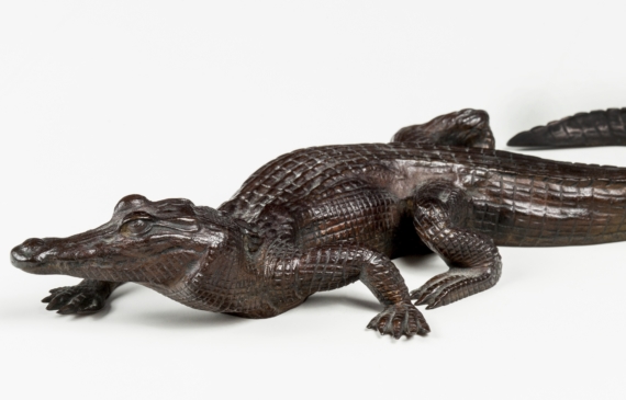 Alt text: Bronze sculpture of a crawling crocodile