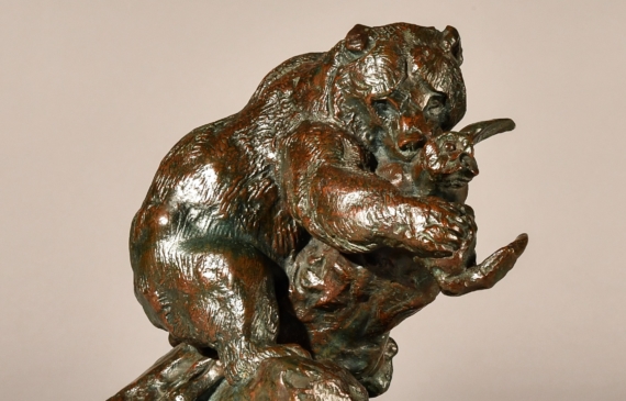 Alt text: Bronze sculpture of a bear catching an owl in his maw