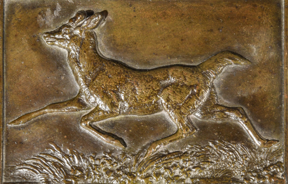 Alt text: Verso of a bronze relief of a trotting deer