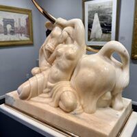 Alt text: Marble sculpture of a woman and a bull with bronze horns
