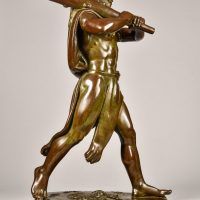 Alt text: Bronze sculpture of Hercules cloaked in a lion skin holding a raised club