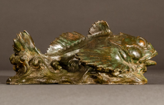 Alt text: Bronze sculpture of a sculpin fish atop the water, side view