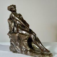 Alt text: Bronze sculpture of a nude woman sitting and reclining