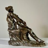 Alt text: Bronze sculpture of a nude woman sitting and reclining