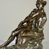Alt text: Bronze sculpture of a nude woman sitting and reclining