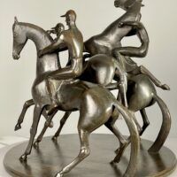 Alt text: bronze sculpture of three men on horseback