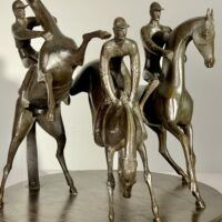 Alt text: bronze sculpture of three men on horseback