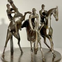 Alt text: bronze sculpture of three men on horseback