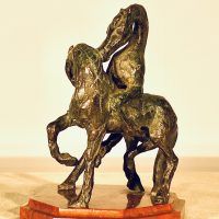 Alt text: Bronze sculpture of two stallions fighting, rear view