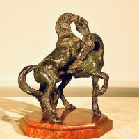Alt text: Bronze sculpture of two stallions fighting, frontal view
