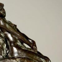 Alt text: Bronze sculpture of a nude woman sitting and reclining
