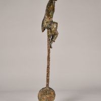 Alt text: Bronze sculpture of a circus performer riding a tall unicycle