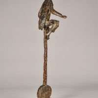 Alt text: Bronze sculpture of a circus performer riding a tall unicycle