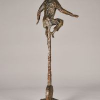 Alt text: Bronze sculpture of a circus performer riding a tall unicycle