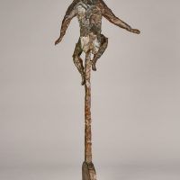 Alt text: Bronze sculpture of a circus performer riding a tall unicycle