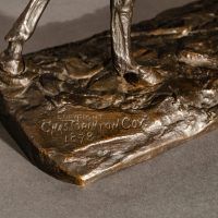 Alt text: Detail of cowboy sculpture base, signed 