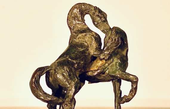 Alt text: Bronze sculpture of two stallions fighting, angled view