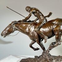 Alt text: Bronze sculpture of a Native American man on horseback