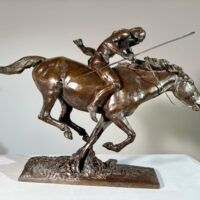 Alt text: Bronze sculpture of a Native American man on horseback