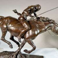Alt text: Bronze sculpture of a Native American man on horseback