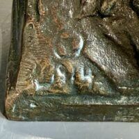 Alt text: Bronze sculpture, date detail