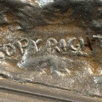 Alt text: Bronze sculpture, inscription detail