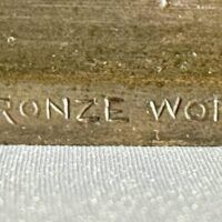 Alt text: Bronze sculpture, foundry mark detail