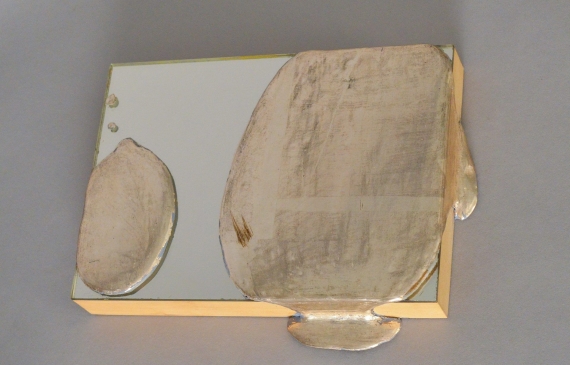 Alt text: Mirror with silver leaf splotches dropped onto it, fixed to wood