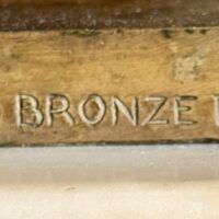 Alt text: Bronze sculpture, foundry mark detail