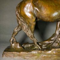 Alt text: Bronze sculpture of a horse bending down alongside a girl sitting near to the ground, peering over a cliff (detail)