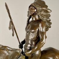 Alt text: Bronze sculpture of a Native American man on a horse