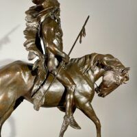 Alt text: Bronze sculpture of a Native American man on a horse