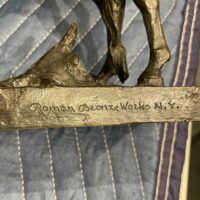 Alt text: Signature detail of a bronze sculpture of a horse