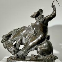 Alt text: Bronze sculpture of a man on a horse with a whip in his hand