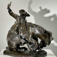 Alt text: Bronze sculpture of a man on a horse with a whip in his hand